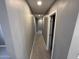 Hallway with neutral paint, grey tile, and doors leading to various rooms at 5042 S 22Nd St, Phoenix, AZ 85040