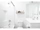 Well-lit bathroom featuring a sink, toilet, and white tub and shower with chrome fixtures and floating shelves at 512 E Bamboo Ln, San Tan Valley, AZ 85140