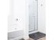 Bathroom with white tub, shower with glass door, and neutral-colored rug on light colored wood flooring at 512 E Bamboo Ln, San Tan Valley, AZ 85140