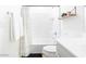 Clean and bright bathroom with a tub and shower, white cabinets, a light wood shelf and white towels at 512 E Bamboo Ln, San Tan Valley, AZ 85140
