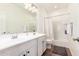 Well-lit bathroom with dual sinks, spacious vanity, and a combined tub and shower at 512 E Bamboo Ln, San Tan Valley, AZ 85140