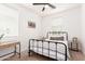 Well-lit bedroom features a black metal bed frame, ceiling fan, and neutral decor for a cozy feel at 512 E Bamboo Ln, San Tan Valley, AZ 85140