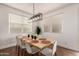 Bright dining area with a wooden table, seating for six, and a modern light fixture above at 512 E Bamboo Ln, San Tan Valley, AZ 85140