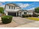 Inviting two-story home showcasing manicured bushes, a dark garage door, and a beautifully paved driveway at 512 E Bamboo Ln, San Tan Valley, AZ 85140