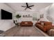 Stylish living room features leather sofas, modern decor, ceiling fan and wood look floors at 512 E Bamboo Ln, San Tan Valley, AZ 85140