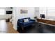 Comfortable living area showcasing a plush blue couch, wood desk, and decorative elements on sleek, dark flooring at 512 E Bamboo Ln, San Tan Valley, AZ 85140