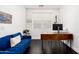 Bright office space featuring a stylish desk, blue sofa, and modern decor for a comfortable workspace at 512 E Bamboo Ln, San Tan Valley, AZ 85140