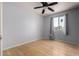 Bedroom with light blue walls, hardwood floors, ceiling fan, and view of palm trees at 5135 E Evergreen St # 1166, Mesa, AZ 85205