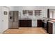 A spacious kitchen features stainless steel appliances, wooden floors, and custom shelves at 5135 E Evergreen St # 1166, Mesa, AZ 85205