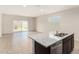 View of the modern kitchen island and living area with sliding door to the backyard at 5240 E Gummite Dr, San Tan Valley, AZ 85143