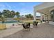 A serene backyard oasis with a sparkling pool, lush landscaping, and a covered patio with comfortable seating at 5827 S Marin Ct, Gilbert, AZ 85298