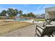 Backyard featuring a swimming pool, stone surround, well-manicured lawn, trees, and a covered patio with seating at 5827 S Marin Ct, Gilbert, AZ 85298
