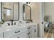 Bright bathroom featuring dual sinks with modern black fixtures, quartz counters, and shiplap accent wall at 5827 S Marin Ct, Gilbert, AZ 85298