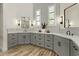 Bathroom with double sinks, gray cabinets, modern fixtures, and hexagon patterned accent wall at 5827 S Marin Ct, Gilbert, AZ 85298