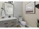 Modern powder room featuring a wood vanity, black hardware, and geometric patterned wallpaper at 5827 S Marin Ct, Gilbert, AZ 85298