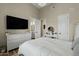 Cozy bedroom with a white dresser, tv, mirror, makeup table, and a comfortable bed, offering a peaceful retreat at 5827 S Marin Ct, Gilbert, AZ 85298