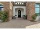 Stunning front entryway with brick accents, manicured plants, and black front door at 5827 S Marin Ct, Gilbert, AZ 85298