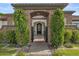 Home's entryway features manicured landscaping, stone archway and iron gate at 5827 S Marin Ct, Gilbert, AZ 85298