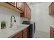 Charming laundry room with granite counters, cabinets, and stainless steel washer and dryer at 5827 S Marin Ct, Gilbert, AZ 85298
