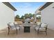 Covered patio with comfortable seating, stone flooring, and a view of the sparkling pool and landscaped backyard at 5827 S Marin Ct, Gilbert, AZ 85298