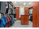 Spacious walk-in closet featuring custom wood shelving, center island, a chandelier, and ample storage space at 5827 S Marin Ct, Gilbert, AZ 85298