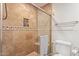 Bathroom featuring travertine tiled shower with glass door, a built-in niche and chrome fixtures at 6231 E Desert Cove Ave, Scottsdale, AZ 85254