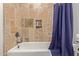 Bathroom featuring tiled shower/tub, a built-in niche and chrome fixtures and a colorful shower curtain at 6231 E Desert Cove Ave, Scottsdale, AZ 85254