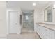Bathroom featuring long vanity with stone counters, lots of cabinets and a glass-enclosed shower at 6231 E Desert Cove Ave, Scottsdale, AZ 85254
