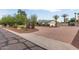 Lovely single-story house boasts a circular driveway, verdant landscaping, and an attached two-car garage at 6231 E Desert Cove Ave, Scottsdale, AZ 85254
