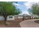 Charming single-story home featuring a brick-accented facade, lush landscaping, and a welcoming circular driveway at 6231 E Desert Cove Ave, Scottsdale, AZ 85254