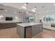 Open concept kitchen features a large island, stainless steel appliances, and an adjacent living area at 6231 E Desert Cove Ave, Scottsdale, AZ 85254