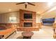 Outdoor fireplace with brick surround, mounted television, and a covered patio seating area at 6231 E Desert Cove Ave, Scottsdale, AZ 85254