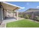 Delightful backyard featuring a covered patio, artificial grass, brick pavers, and a peaceful outdoor seating area at 6317 S Kimberlee Way, Chandler, AZ 85249