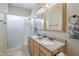 Bathroom featuring a double vanity, framed mirrors, and a glass-enclosed shower, all set in a neutral palette at 6317 S Kimberlee Way, Chandler, AZ 85249