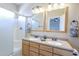 Bathroom featuring a double vanity, framed mirrors, and a glass-enclosed shower, with ample lighting at 6317 S Kimberlee Way, Chandler, AZ 85249