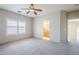 Light-filled main bedroom with carpet, neutral walls, ceiling fan, and an open doorway to the en-suite bathroom at 6317 S Kimberlee Way, Chandler, AZ 85249