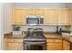 Close up of kitchen showcasing stainless steel microwave and gas range with cooktop at 6317 S Kimberlee Way, Chandler, AZ 85249