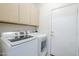 This laundry room includes both a washing machine and a dryer and overhead cabinets at 6317 S Kimberlee Way, Chandler, AZ 85249