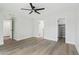 Bright bedroom features a ceiling fan, wood-look floors, and doorways to the closet and bathroom at 6629 N Majorca E Way, Phoenix, AZ 85016