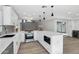 Bright white kitchen with stainless appliances, eat-in island, and modern pendant lighting at 6629 N Majorca E Way, Phoenix, AZ 85016