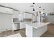 Bright white kitchen with stainless appliances, eat-in island, and modern pendant lighting at 6629 N Majorca E Way, Phoenix, AZ 85016
