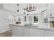 Bright white kitchen with stainless appliances, eat-in island, and modern pendant lighting at 6629 N Majorca E Way, Phoenix, AZ 85016
