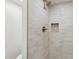 Shower features stone look tiling and bronze fixtures with a built-in mosaic shelf at 6629 N Majorca E Way, Phoenix, AZ 85016