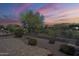 Desert backyard with patio, desert landscaping, and sunset sky at 7094 E Palo Brea Dr, Gold Canyon, AZ 85118