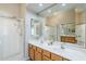 Bright bathroom featuring a double sink vanity, walk-in shower, and large mirror at 7094 E Palo Brea Dr, Gold Canyon, AZ 85118