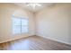 A cozy bedroom with hardwood floors, a large window, and a ceiling fan at 7094 E Palo Brea Dr, Gold Canyon, AZ 85118