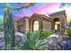 Inviting single-story home featuring desert landscaping, a two-car garage, and a charming walkway to the front door at 7094 E Palo Brea Dr, Gold Canyon, AZ 85118
