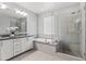 Modern bathroom features dual sinks, a soaking tub and a walk-in glass shower at 7472 E Paraiso Dr, Scottsdale, AZ 85255