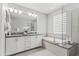 Modern bathroom features dual sinks, a soaking tub and a walk-in glass shower at 7472 E Paraiso Dr, Scottsdale, AZ 85255