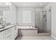 Modern bathroom features dual sinks, a soaking tub and a walk-in glass shower at 7472 E Paraiso Dr, Scottsdale, AZ 85255
